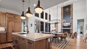 A spacious kitchen with a large island, wooden cabinets, and pendant lighting. - Red Ledges vista, hottub, golf, min 90 day stay (Heber City)