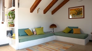 Une pièce chaleureuse avec un canapé intégré, un tapis à motifs et un tableau accroché au mur.
