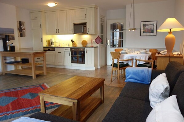 A compact living space with a kitchen, dining area, and a sofa.