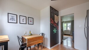 Eine moderne Küche mit einem Holzespeisetisch, Stühlen und einem Kühlschrank.
