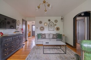 A living room with a sofa, coffee table, and a TV on a stand. - Walk to Stadium | Starbucks on Corner | Near Shops (Columbus)
