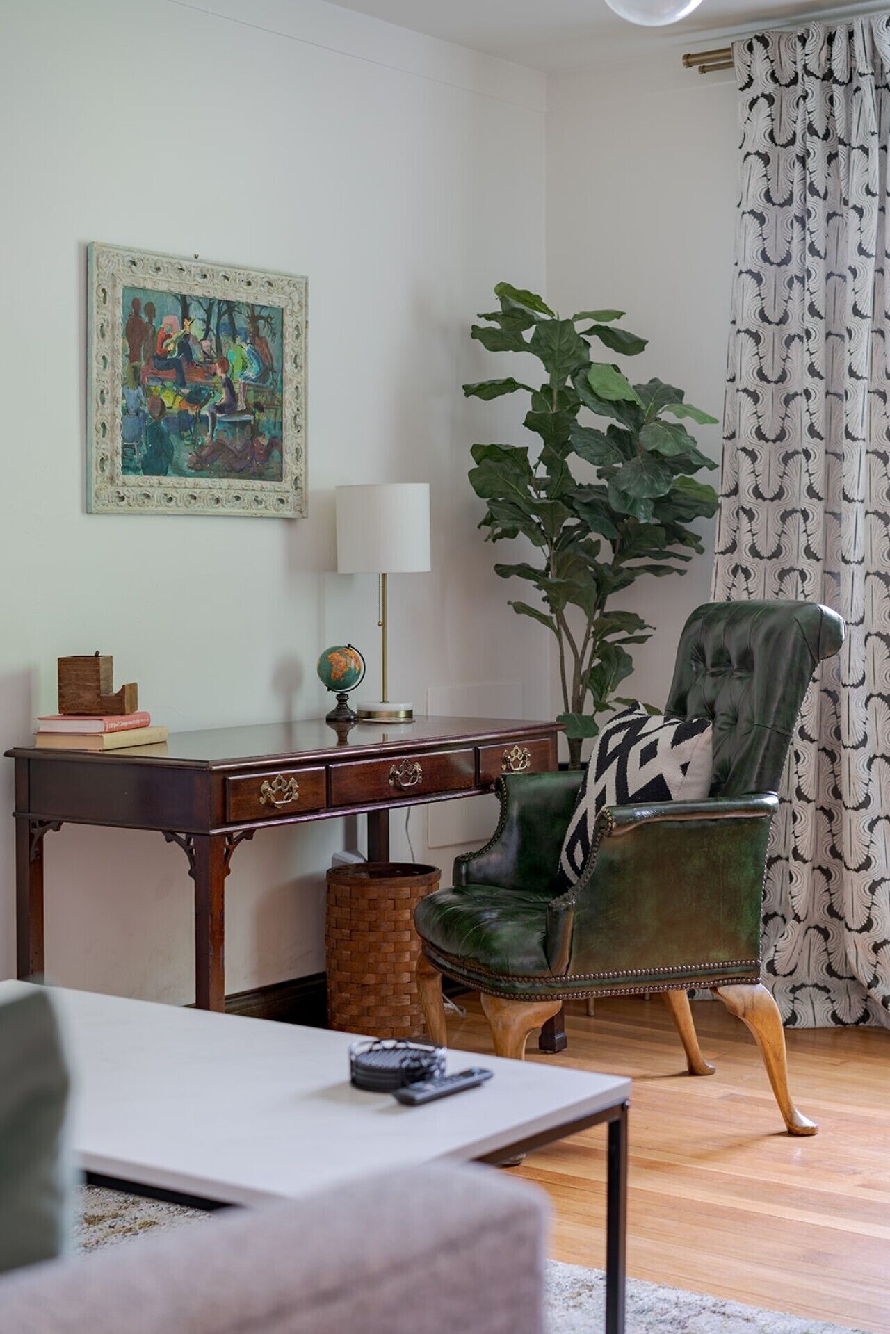 A room with a desk, a chair, a lamp, a plant, and a curtain.