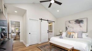 A bedroom with a bed, a bench, a ceiling fan, and a large abstract painting on the wall. - Spacious 3-Bedroom Home with King Suite, Parking Permits, and Prime Location Near Downtown Columbus (Columbus)