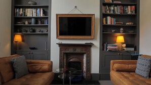 A living room with two sofas, a fireplace, and bookshelves.