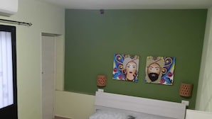 A bedroom with a bed, green walls, and two paintings. - Studio apartment with kitchen in Center "Stay in Catania" (Catania)