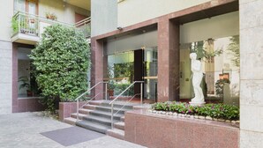 A building entrance with a statue, steps, and a potted plant. - Easylife - Contemporary design on the Navigli (Milano)
