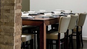 A conference room with a long table, six chairs, and a brick wall. - Seaside Country Escape (Torquay)