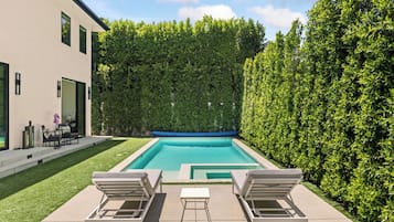 Een buitenzwembad en ligstoelen