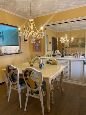 A dining area with a table, chairs, and a chandelier.