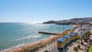 A coastal town with a tram line, beach, and a pier. - Apartment 'Vista Mar' with Sea View, Wi-Fi and Air Conditioning (Albufeira)