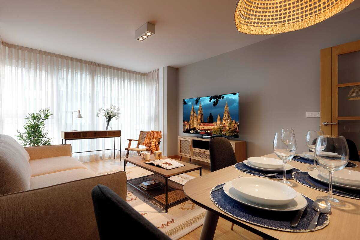 Un salon moderne avec un canapé, une table basse et un coin repas préparé pour un repas.