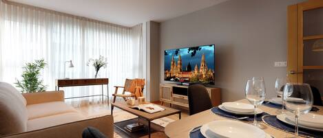A modern living room with a sofa, coffee table, and dining area set for a meal.