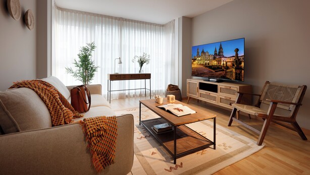 A modern living room with a sofa, coffee table, TV, and a view of a cityscape. - Vita Homes by Upper Luxury Housing (Santiago de Compostela)