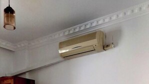 A hotel room with two beds, a wooden wardrobe, and an air conditioning unit on the wall. - Akasya Pansiyon & Apart (Anamur)