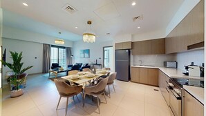 A modern kitchen with wooden cabinets, a built-in oven, and a microwave. - Vibrant 2 Bedroom l Pool with Burj Khalifa View (Downtown Dubai)