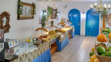 A buffet setup with a coffee machine, various food items, and a fruit display.