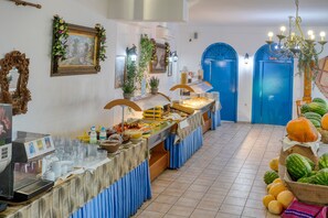 Ein reichhaltiges Buffet mit Kaffeemaschine, Speisen und einer Obstauslage.