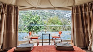 Una camera da tenda con un letto, due sedie e un tavolo.