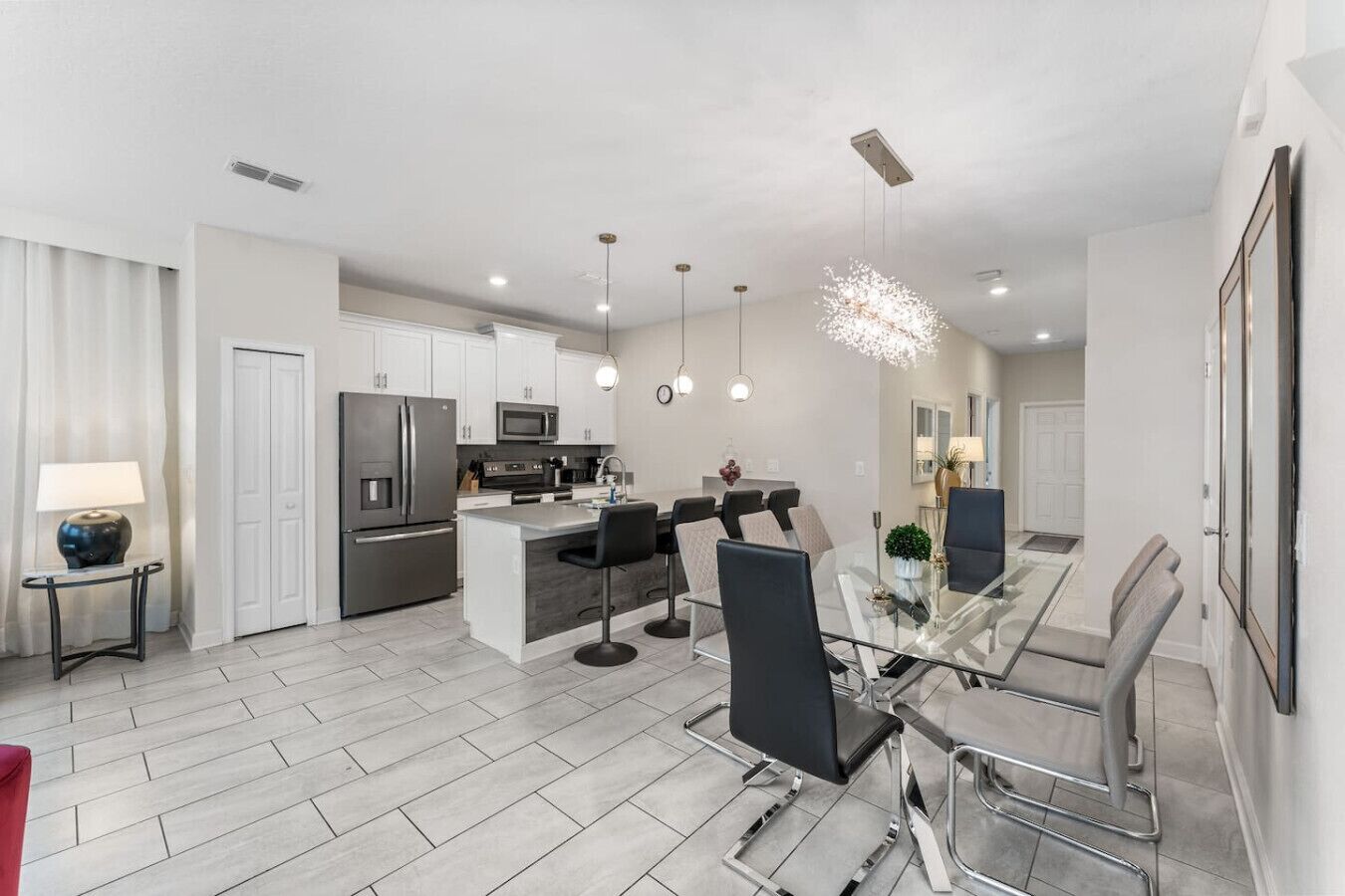 A modern kitchen with white cabinets, stainless steel appliances, and a central island with bar stools.