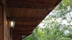 A wooden balcony with a railing, a small table, and two chairs. - Apartament przy Potoku 25 z parkingiem (Zakopane)