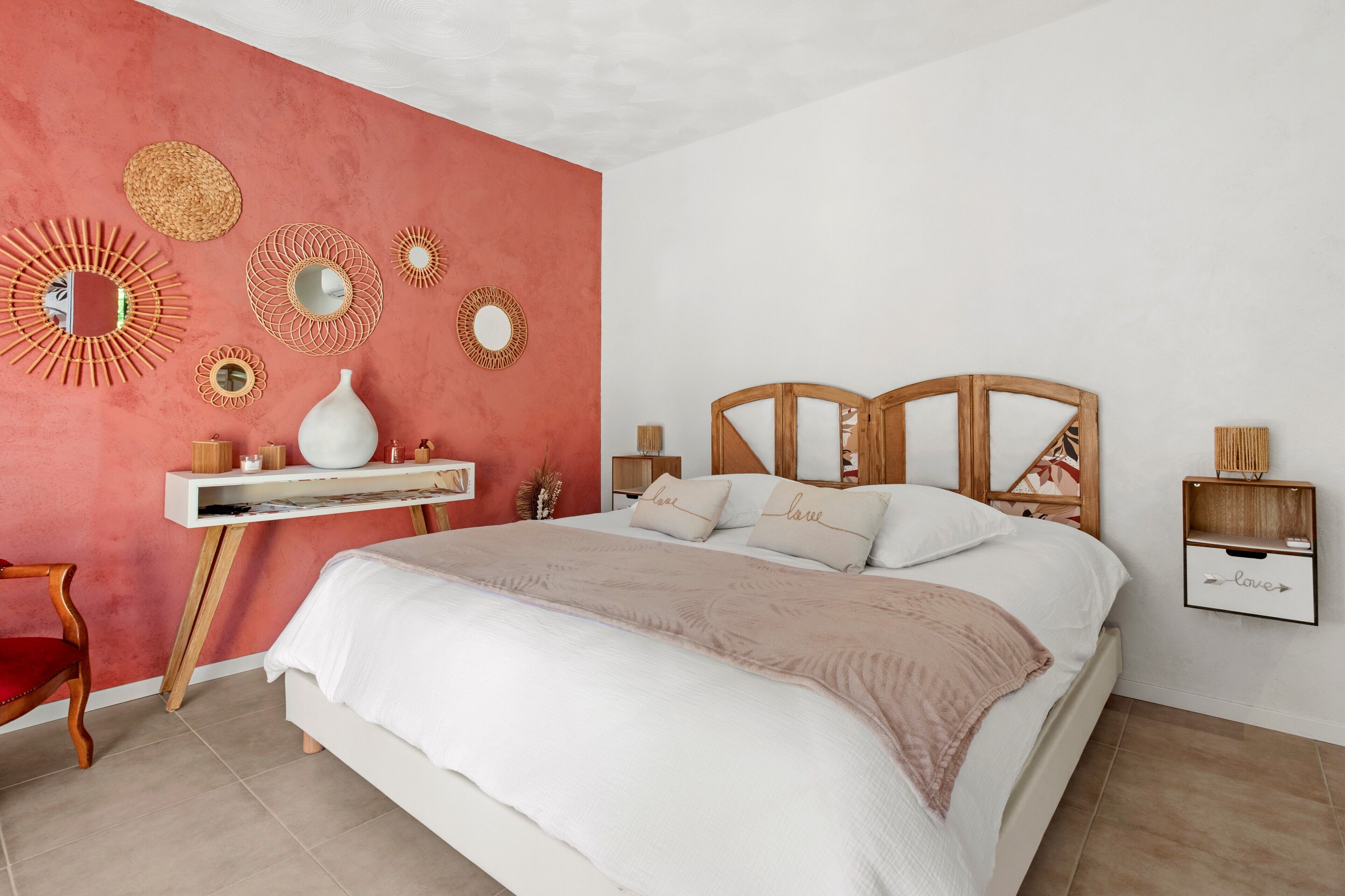 Ein Schlafzimmer mit Bett, Schminktisch, Stuhl und Wanddekoration.