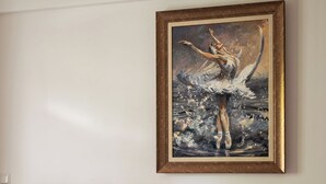 A bedroom with a large bed, a headboard, a wall-mounted lamp, and a framed painting. - Apartament przy Potoku 26 z parkingiem (Zakopane)