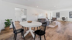 A spacious living area with a round dining table, black chairs, and a grey sofa. - Modern Farmhouse Getaway (Leesburg)