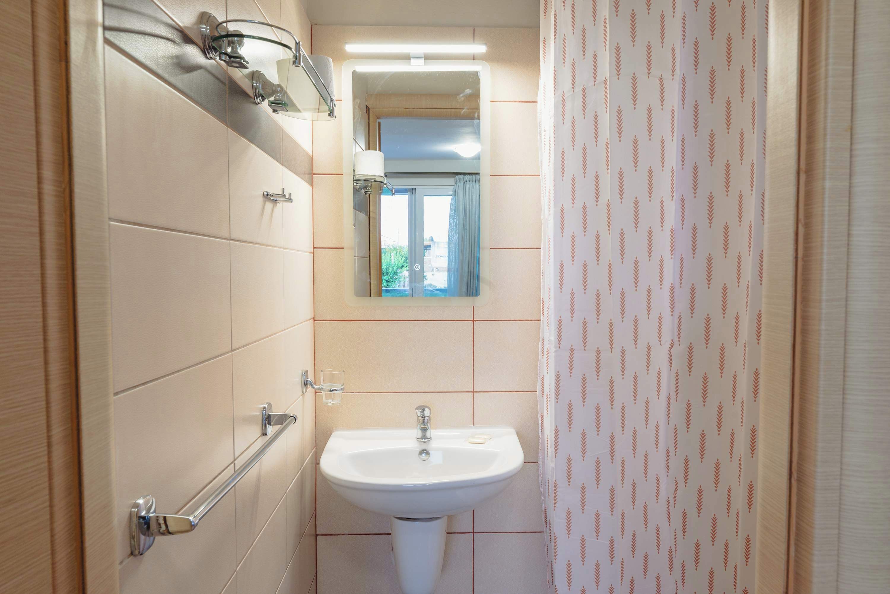 A bathroom with a white sink, a mirror above it, and a towel rack.