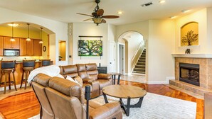 A spacious living room with a leather sofa, a coffee table, and a fireplace. - Steps to Bay: Tranquil Navarre Retreat w/ Balcony (Navarre)