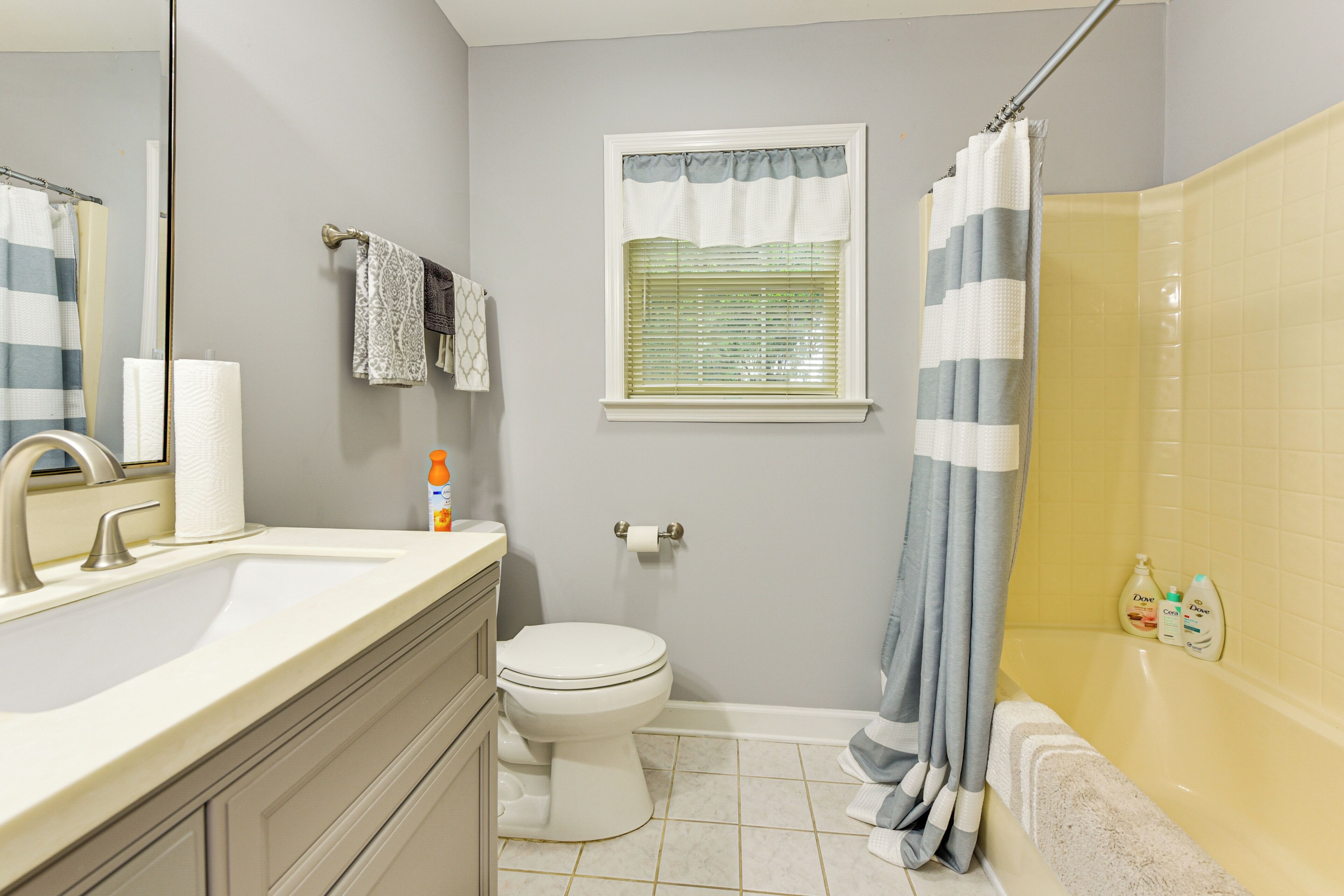 A bathroom with a toilet, sink, and shower area.