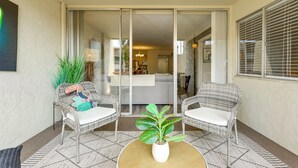 A balcony with wicker chairs, a potted plant, and a patterned rug. - Walkable Old Town Scottsdale Condo: Pool & Hot Tub (Scottsdale)