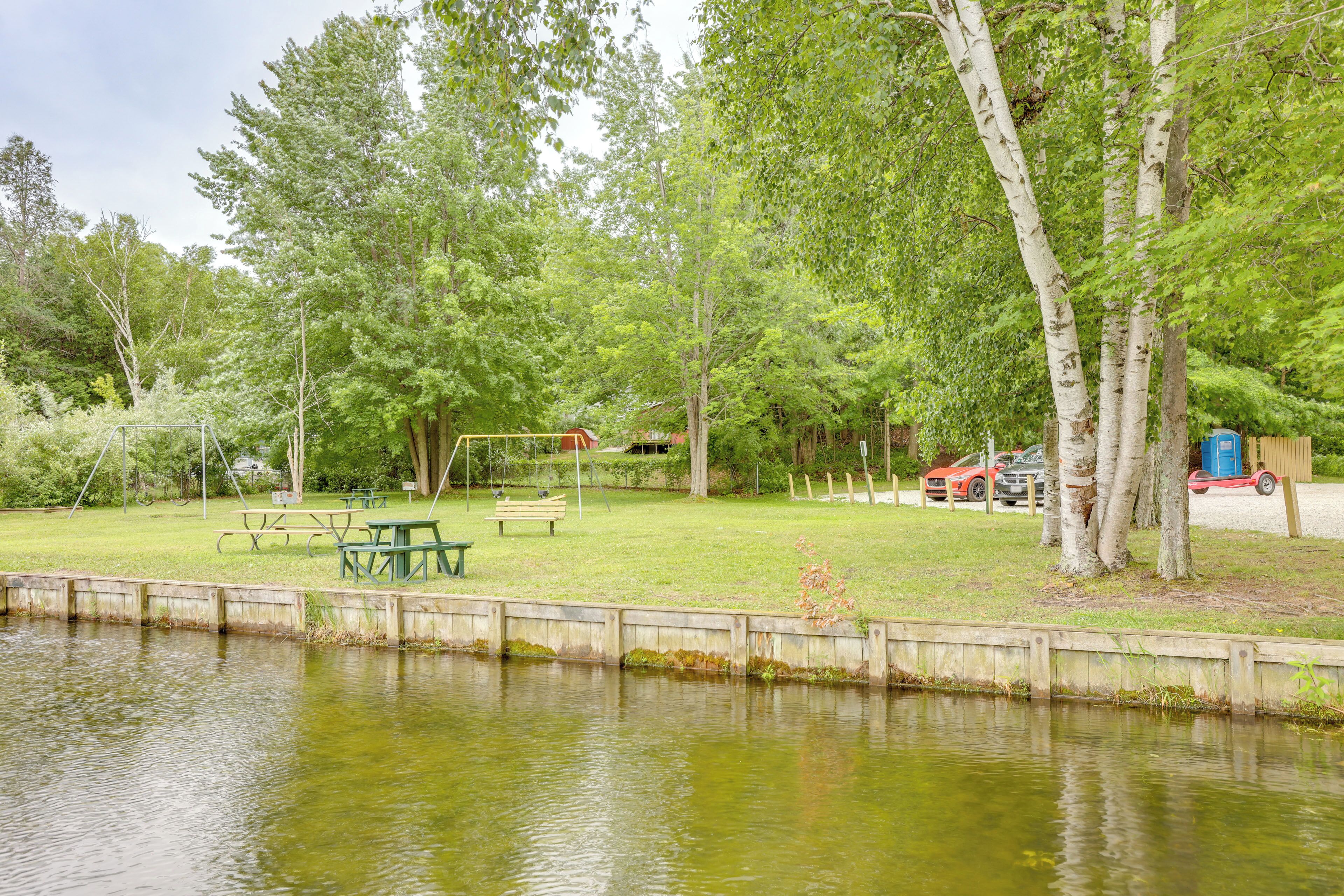 A park with a picnic table, benches, and a playground.