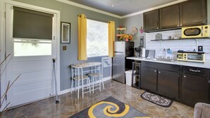 A compact kitchen with a refrigerator, microwave, and a small dining table with chairs. - 5 Mi to Mt Vernon Shops: Peaceful Cottage! (Glenwood)