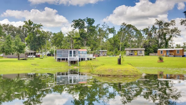 A lakeside property with a dock, a small building with a deck, and a larger building with a yellow door. - 5 Mi to Mt Vernon Shops: Peaceful Cottage! (Glenwood)