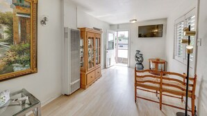 A hallway with a wooden bench, a glass table, a cabinet, and a painting on the wall. - Fullerton Home Base: Easy Access to Dtwn + Csuf! (Fullerton)