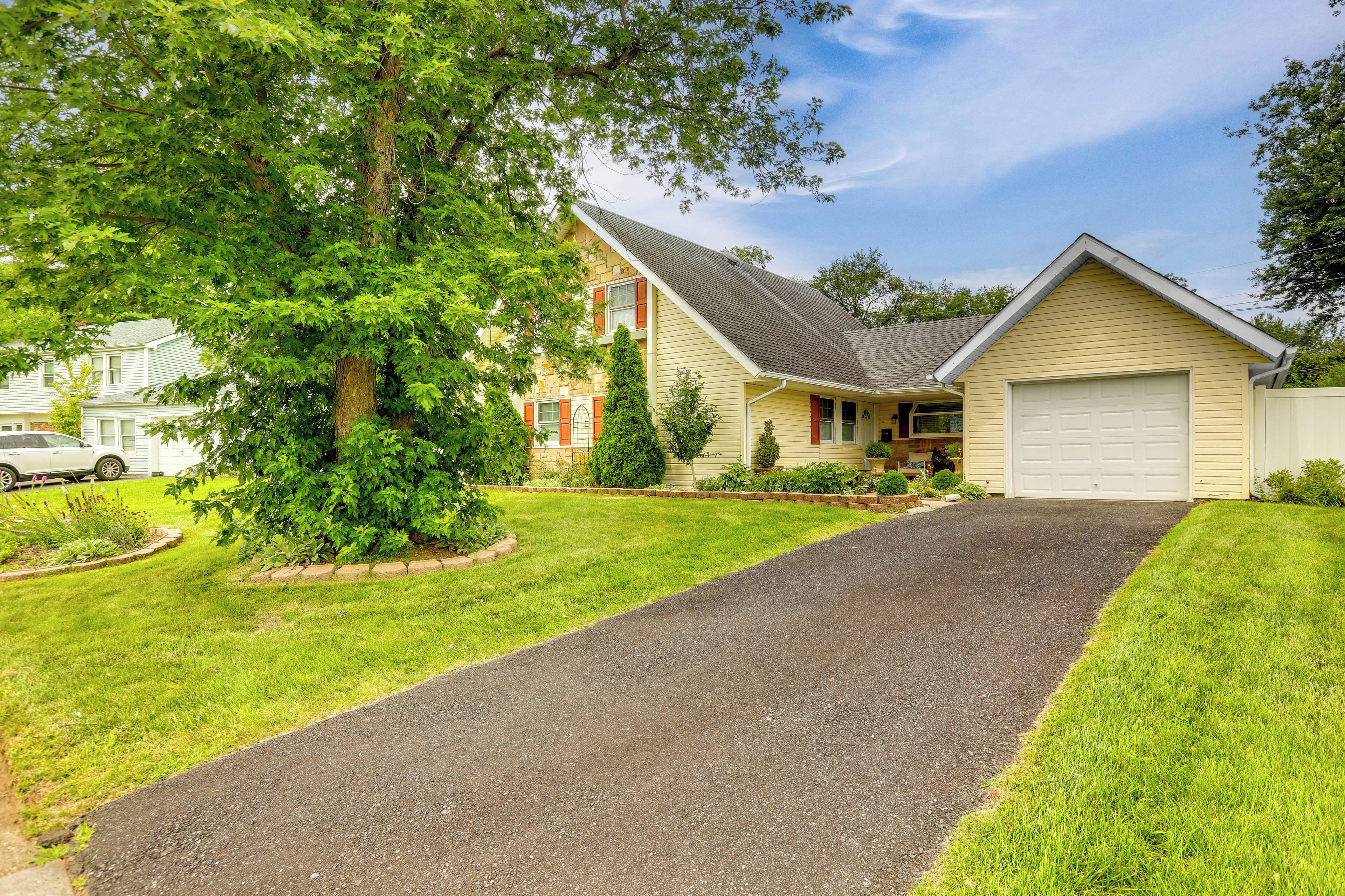 A two-story house with a driveway leading to a garage.
