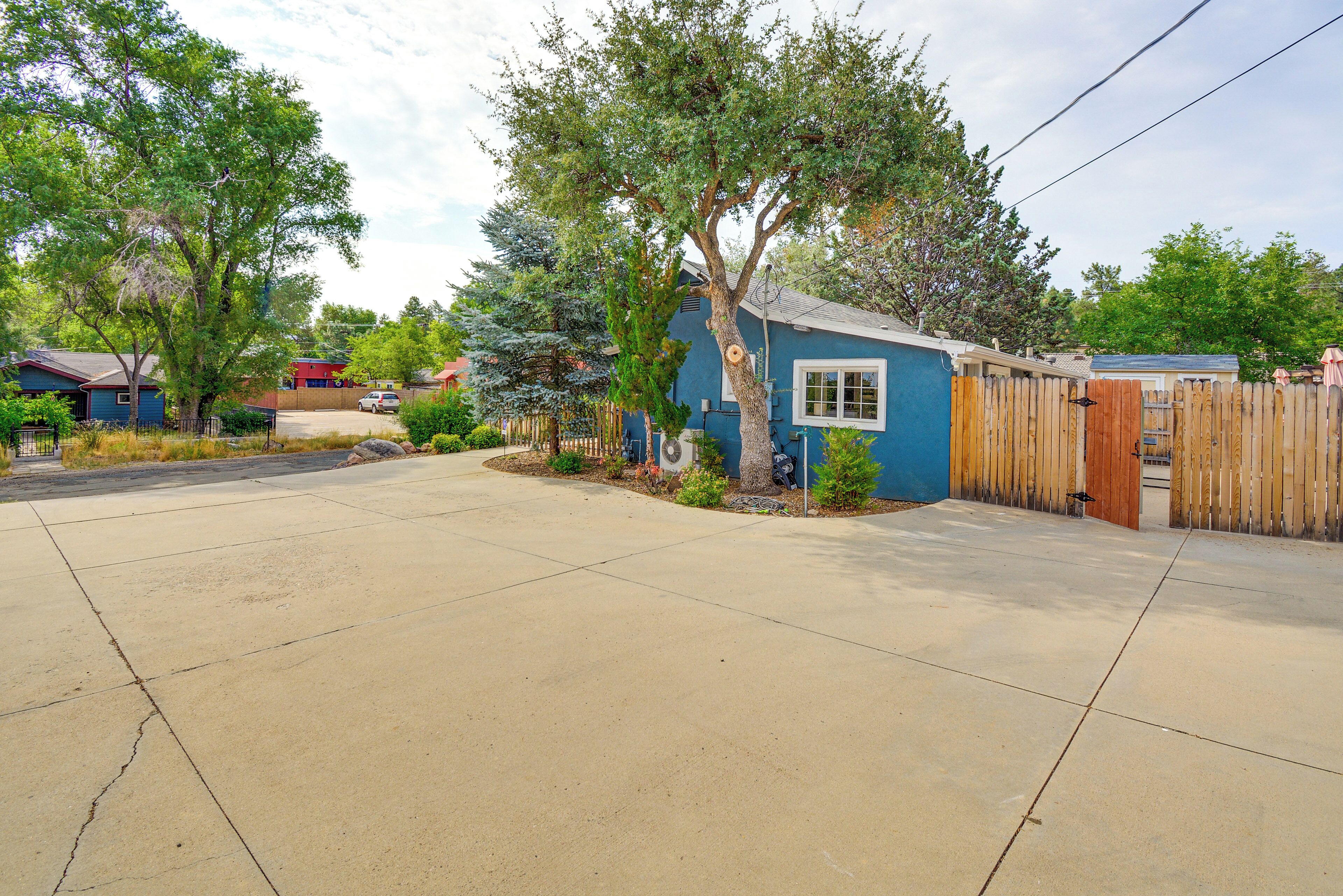 A residential property with a blue house, a wooden fence, and a driveway.