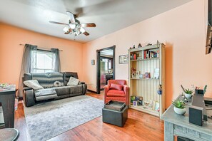 A living room with a sofa, armchair, coffee table, and bookshelf. - Close to Airport: Home in the Heart of Charlotte! (Charlotte)