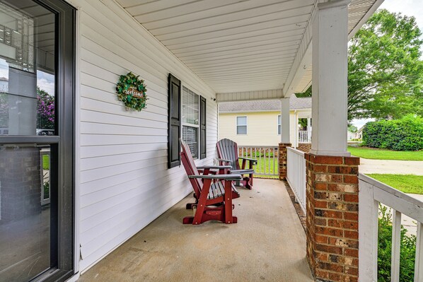 A porch with two Adirondack chairs, a welcome wreath, and a brick column. - < 1 Mi to River & Downtown Belmont: Cozy Cottage (Belmont)