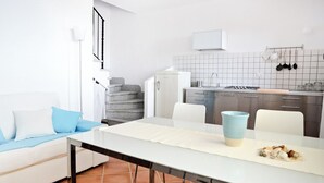 A modern kitchen with white cabinets, a gas stove, and a hanging pot rack. - Lovely house with breathtaking view (Nebida)