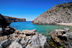 A rocky coastline with clear blue water, a sandy beach, and a mountainous backdrop. - Lovely house with breathtaking view (Nebida)