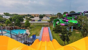Un parco acquatico con un lungo scivolo, più scivoli d'acqua e una piscina.
