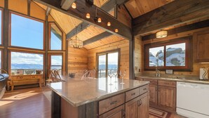 A spacious kitchen with wooden cabinets, a large island, and a view of mountains through the windows. - 273 Fallen Rock BIG Views 4 Bed Home, Pet Friendly + Hot Tub! (Tabernash)