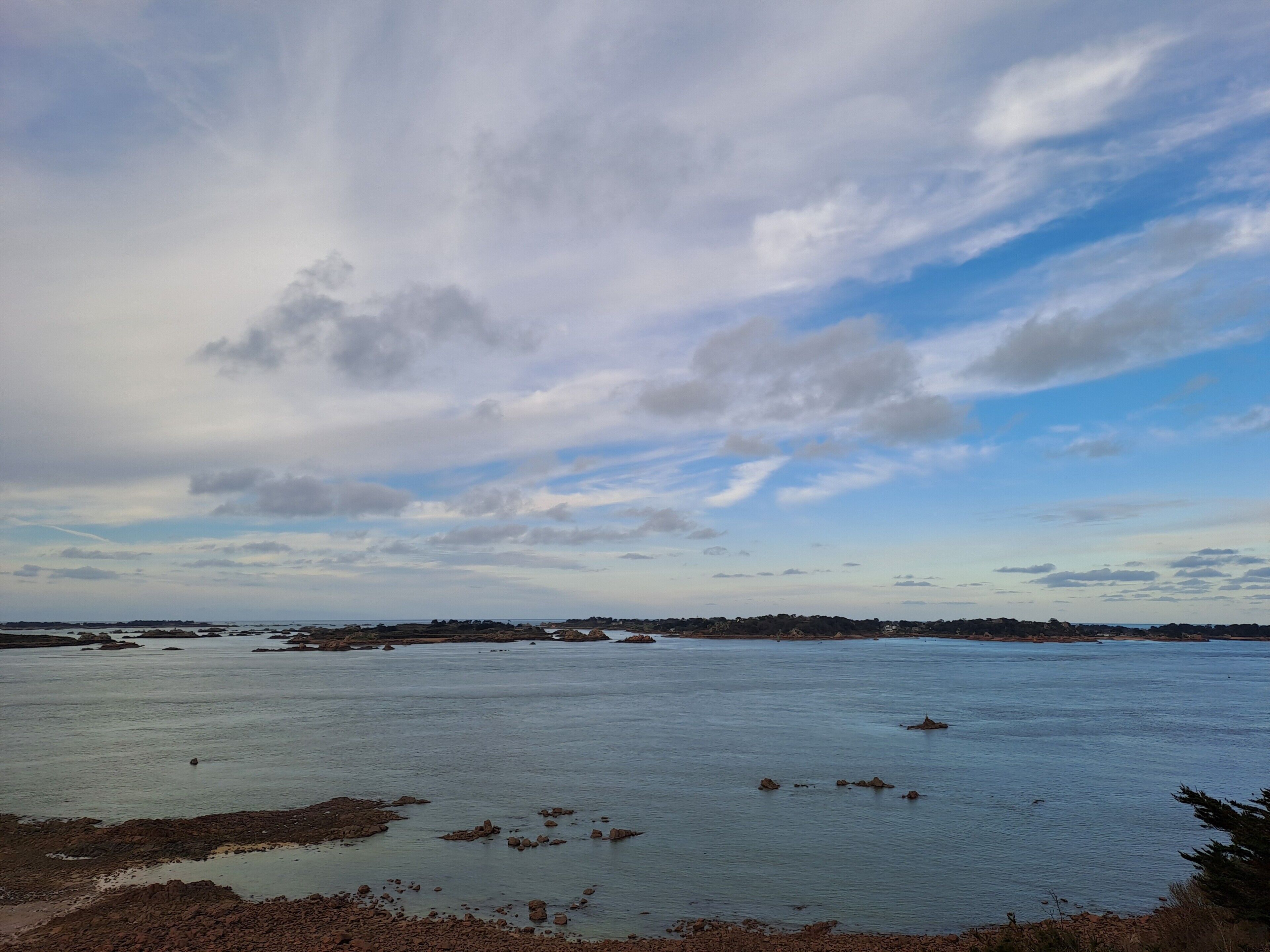 A coastal landscape with a view of the sea and distant land.