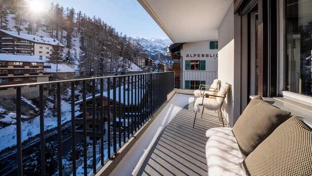 A balcony with a view of a snowy mountain landscape, a sofa, and a sign reading "ALPENBLICK". - Apartment Sofi- Inspiringplaces Zermatt (Zermatt)