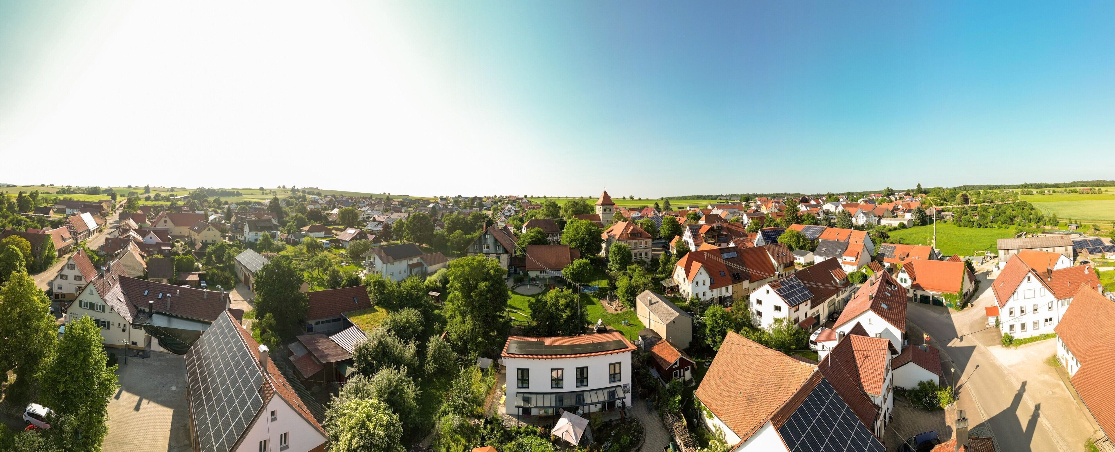 A town with traditional architecture, including houses with sloped roofs and a church with a tower.
