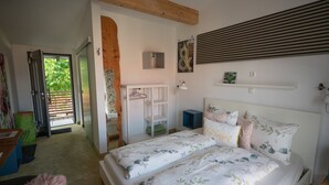 A bedroom with a bed, a bedside table, a nightstand, a wardrobe, a mirror, and a door leading to a balcony. - Room 'No. 4' with Shared Terrace, Communal Garden and Wi-Fi (Bad Urach)