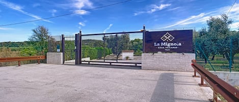 Una entrada con portón y un letrero que dice 'La Mignola Casa Vacanze'.