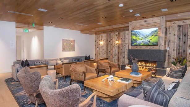 A modern lounge area with wooden flooring, a fireplace, and a large flat-screen TV. - New Mtn Modern with Luxurious Amenities | F305 (Avon)