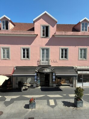 A pink building with a central entrance, multiple windows, and a tiled roof. - Sintra Flower Vintage Chalet (Sintra)